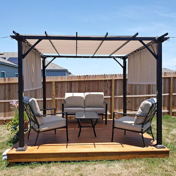 A pergola provides shade over a wooden deck, where two white chairs and a small table are arranged.